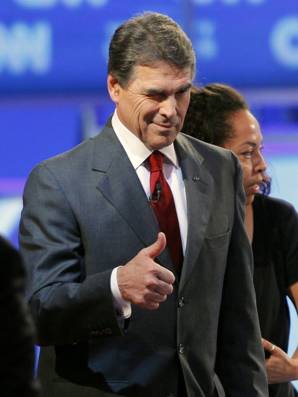 Texas Governor Rick Perry gives a thumbs up and winks during the CNNTea Party Republican presidential candidates debate in Tampa, Florida September 12, 2011.