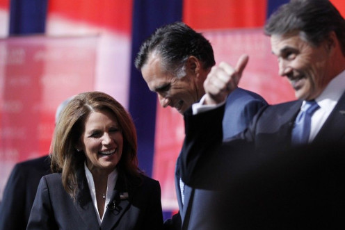 Rep. Michele Bachmann (R-MN) talks to former Massachusetts Governor Mitt Romney (C) and Texas Governor Rick Perry (R) on stage before the Reagan Centennial GOP presidential primary debate at the Ronald Reagan Presidential Library in Simi Valley, Californi