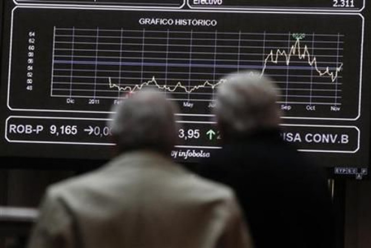 Two men look at screens at the bourse in Madrid
