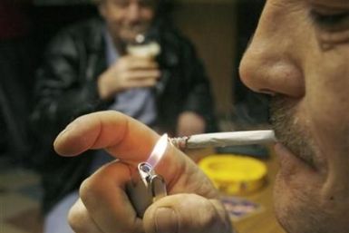 A man lights a cigarette at Brambles Farm working mens club in Middlesbrough