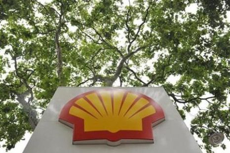 A logo is seen under a canopy of trees at a Shell gas station in central London