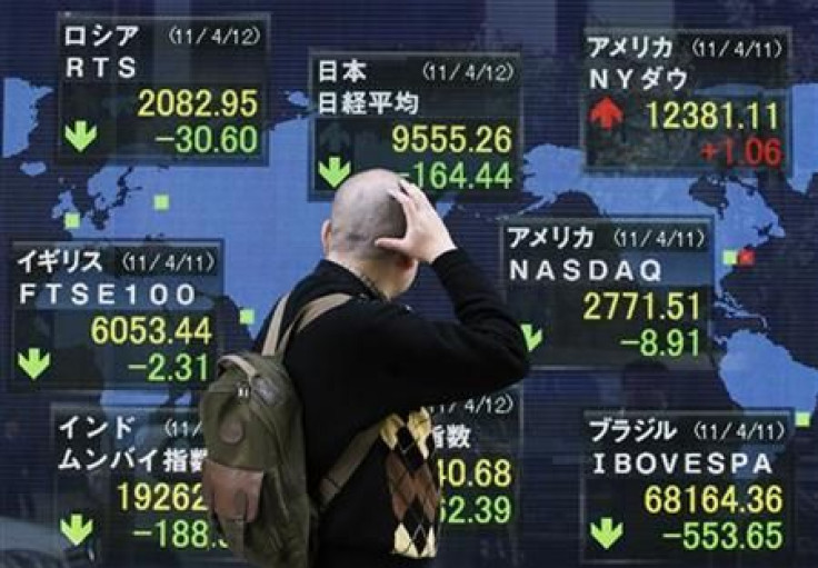A man looks at the closing price of Japan&#039;s Nikkei share average displayed along with major indices outside a brokerage in Tokyo
