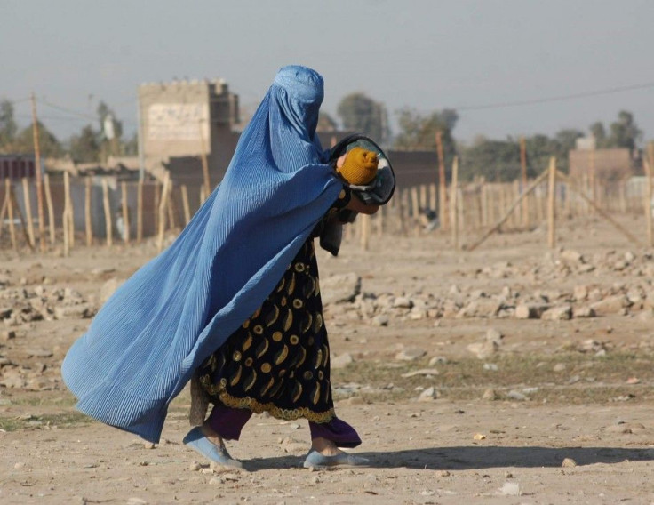 A woman clad in a burqa in Afghanistan with her child