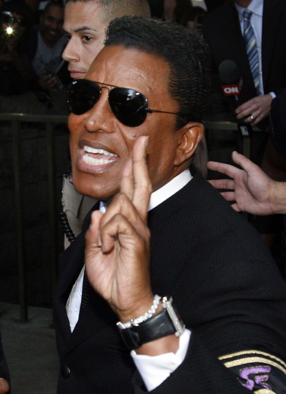 Michael Jacksons brother Jermaine Jackson leaves the courthouse with his fingers crossed after the reading of the guilty verdict in Dr. Conrad Murrays trial in Los Angeles