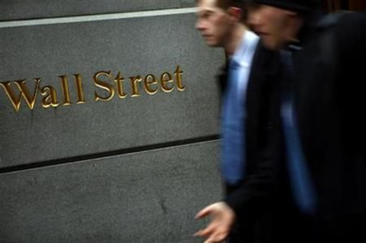 People walk past the New York Stock Exchange on Wall Street