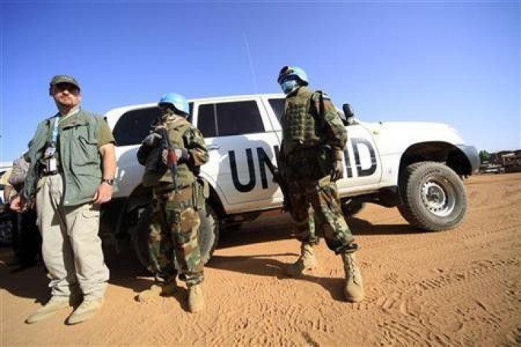 Peacekeepers stand guard near the vehicles of the U.N.