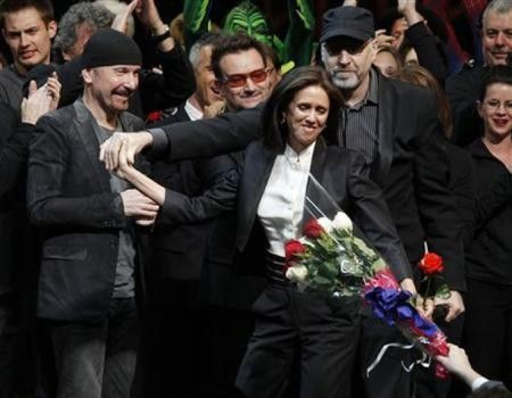 Director Julie Taymor (C) is handed a bouquet of flowers as she takes the stage along with The Edge (L) and Bono of U2 and director Philip William McKinley (R) during the curtain call for the Broadway opening of &#039;&#039;Spider-Man: Turn Off The Dark&#