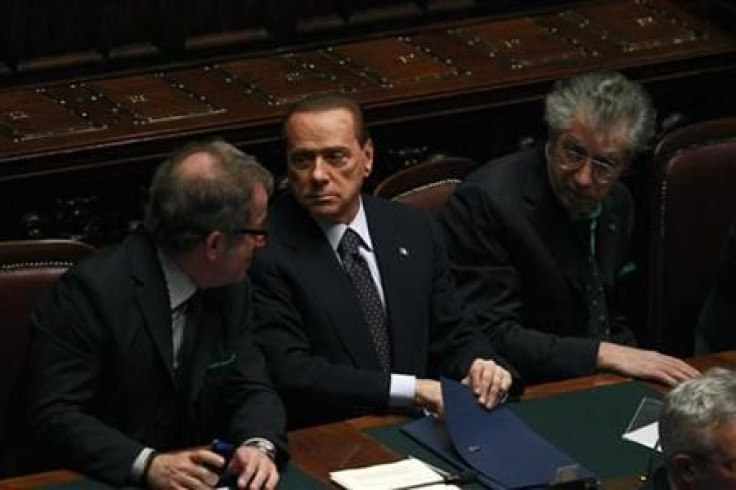 Italian PM Berlusconi holds and saves a memo during a finances vote at the parliament in Rome