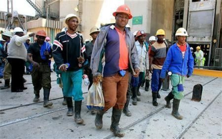 Mine workers emerge from the pithead at the Harmony Gold mine in Carletonville, west of Johannesburg,