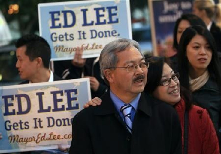 San Francisco Mayor Ed Lee and his wife, Anita greet commuters on election day in San Francisco, California November 8, 2011.