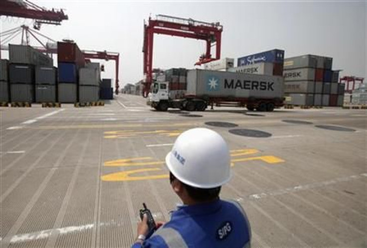 A port worker holds a radio as he works at a container area at the Yangshan Deep Water Port, south of Shanghai