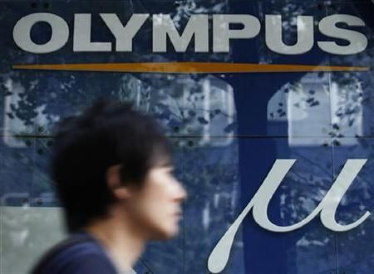A man walks past an advertisement of Japan&#039;s Olympus Corp in Tokyo