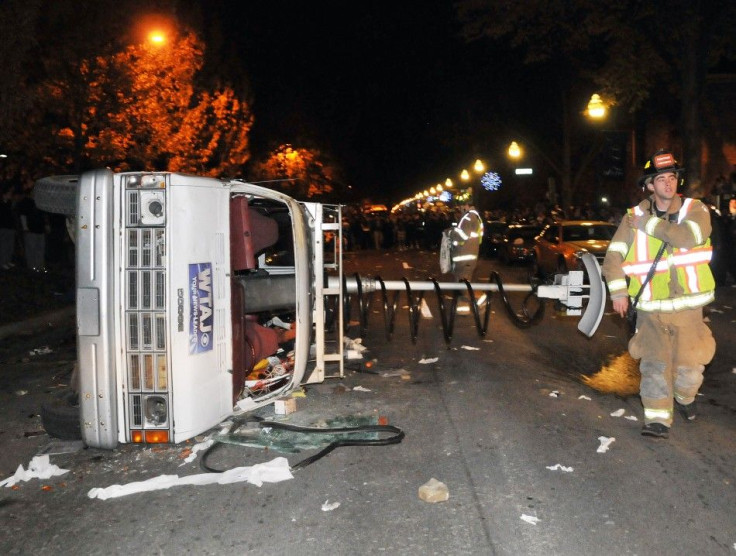Overturned news van is seen as students protest against the firing of Penn State football coach Paterno in State College