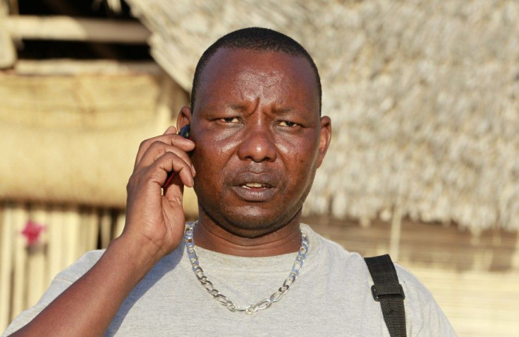 Kenyan Lepapa Moyo talks on his cellphone outside their beach home in Ras-Kitau on Manda Island in Lamu