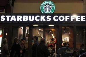 Customers are seen at a Starbucks coffee store which displays their old logo in Paris