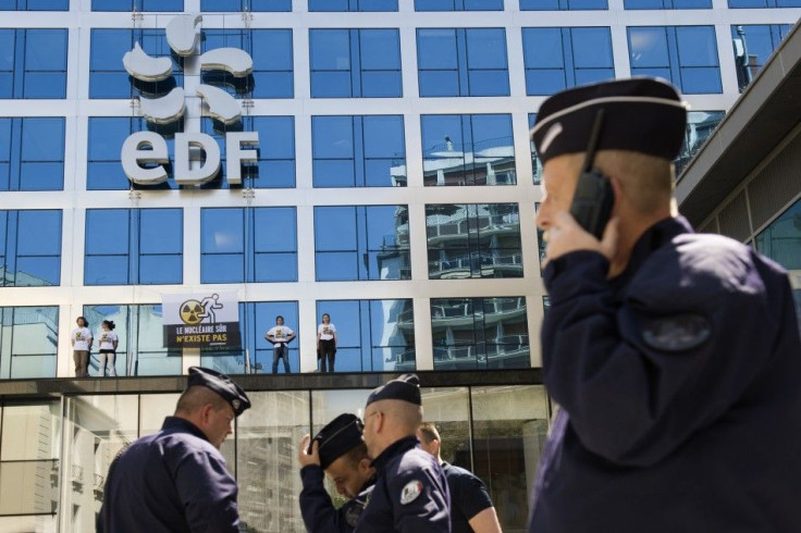 French police take position outside EDF headquarters as Greenpeace members stand on a building ledge with a protest banner in Paris