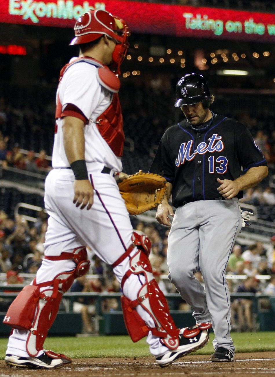New York Mets catcher Mike Nickeas comes into to score on a base hit by Mets Justin Turner in front of Washington Nationals catcher Wilson Ramos during the third inning of their MLB National League baseball game in Washington