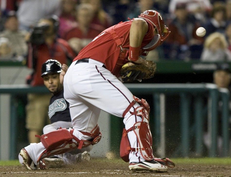 The ball gets away from Nationals Ramos as Infante scores during their MLB National League baseball game in Washington