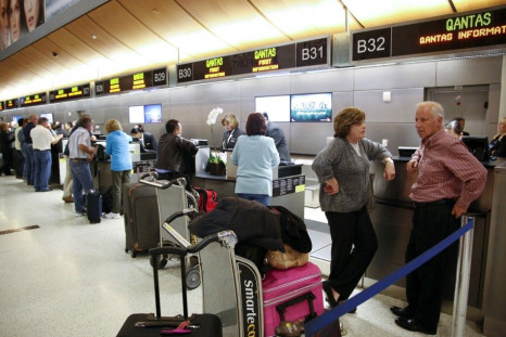 Passengers receive assistance at the Qantas Airlines counter after it canceled flights from Los Angeles International Airport in California.