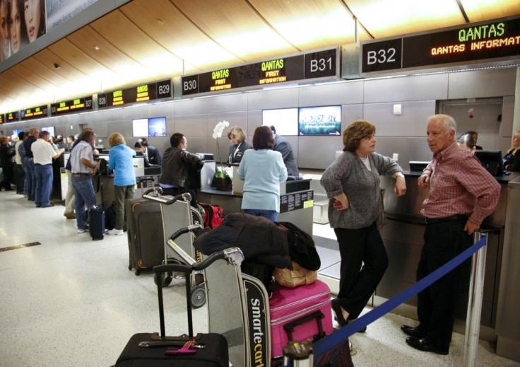 Passengers receive assistance at the Qantas Airlines counter after it canceled flights from Los Angeles International Airport in California.