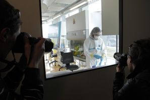 Photographers take a picture of a lab assistant preparing an experiment at new P3 level research laboratory against tuberculosis in Lausanne.