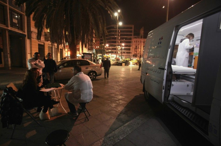 Nurse Maria Vatista works inside a mobile HIV testing van as another medic sits outside with immigrants in Omonia square in Athens Oct. 31, 2011.