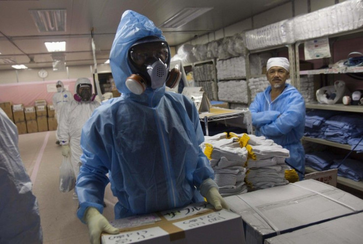 Workers in protective suits and masks work inside the emergency operations center at the crippled Fukushima Daiichi nuclear power plant in Fukushima