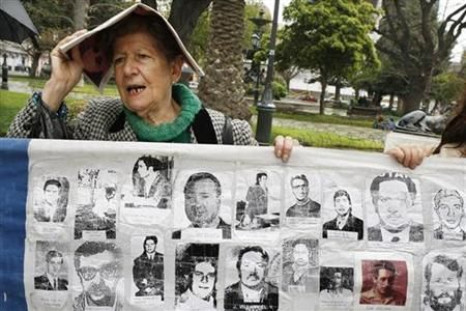 Member of Chilean human rights group Detained and Disappeared displays images of people who vanished during August Pinochet's dictatorship