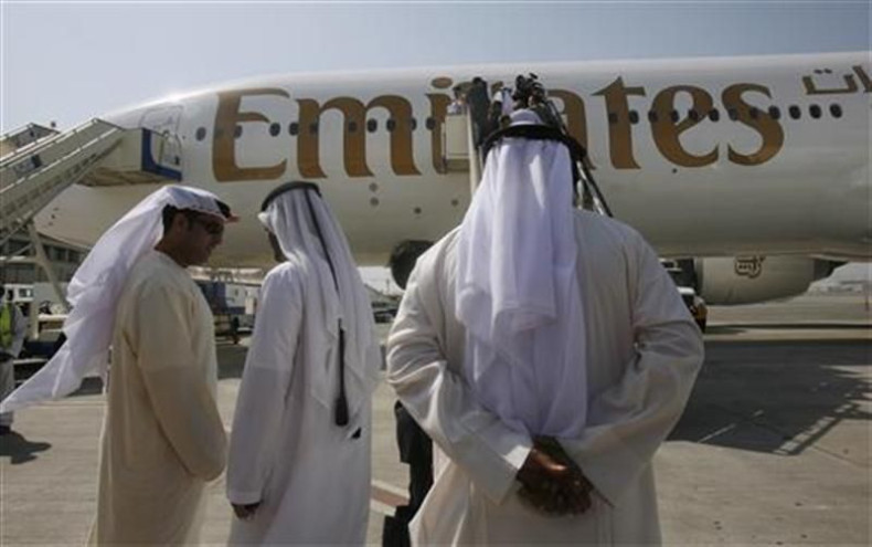 Local people stand near an Emirates airplane at Dubai airport