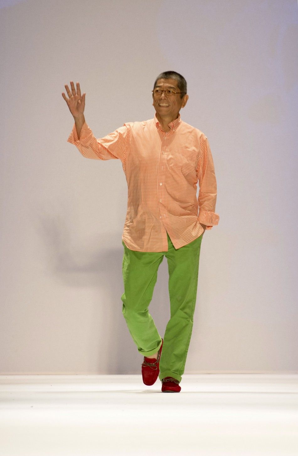 Fashion designer Tadashi Shoji waves to the audience after showing his SpringSummer 2013 collection during New York Fashion Week September 6, 2012.