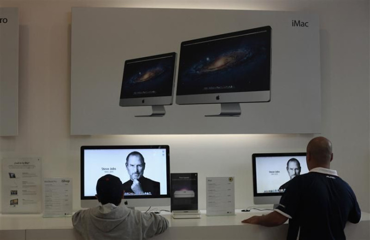Two people look at the image of Steve Jobs on Apple computers inside the iShop in Guatemala City