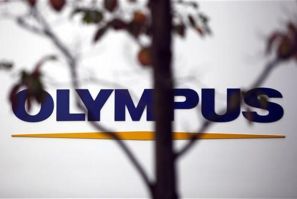 A sign of Olympus Corp is seen behind a tree a outside the company&#039;s showroom in Tokyo