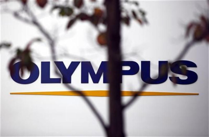 A sign of Olympus Corp is seen behind a tree a outside the company&#039;s showroom in Tokyo