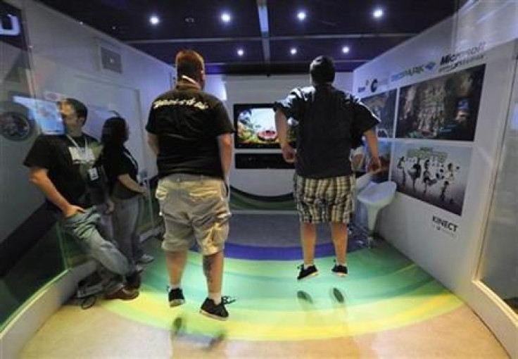 Attendees play Kinect Adventures for Microsoft Xbox in an enclosed booth at the E3 Media & Business Summit in Los Angeles