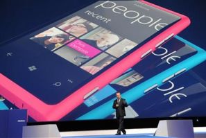 Nokia CEO Stephen Elop walks under a graphic of the new Nokia Lumia smart phone as he speaks at the Nokia World event in London