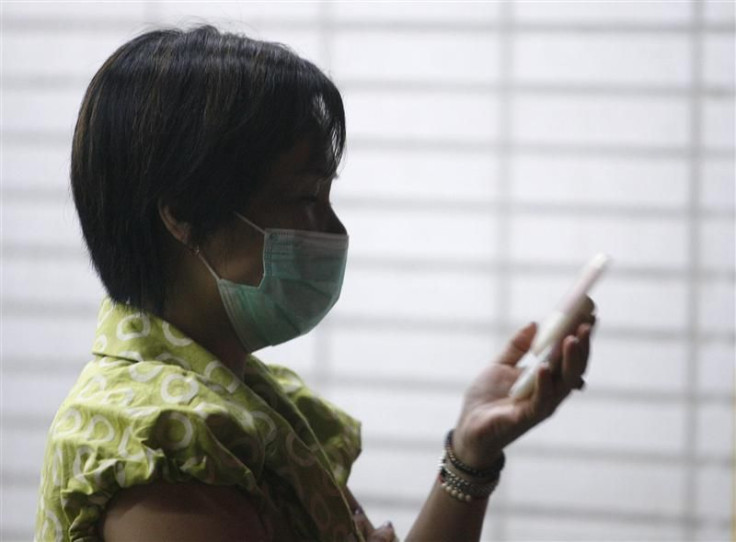A woman wearing a medical mask uses her mobile phone outside a hospital in Taiwan