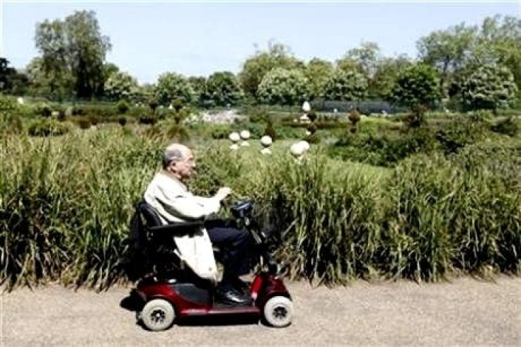 An elderly man in a electric wheelchair smokes a cigar as he rides through Hyde Park in London, May 19, 2010.