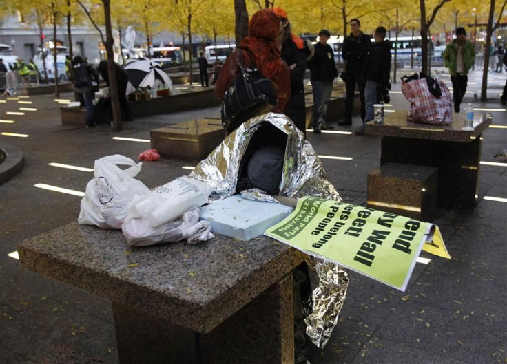 An Occupy Wall Street demonstrator sleeps next to a table at Zuccotti Park in New York
