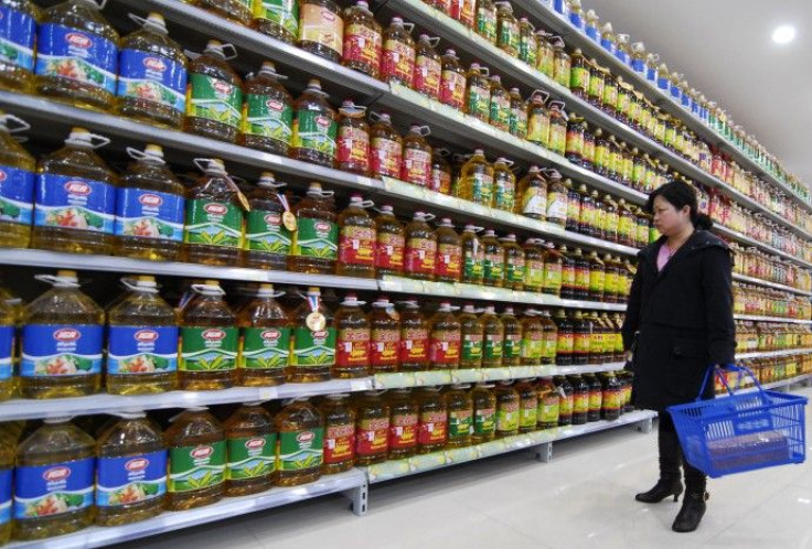 A woman buys cooking oil at a supermarket in Xiangfan