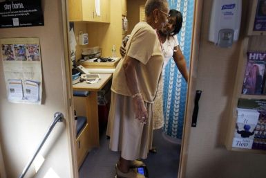 Healthcare educator Rainelle White (rear) checks the weight of client Norma Ferguson in the Family Van in Boston