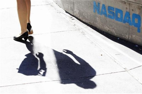 A pedestrian walks past the NASDAQ building in New York City