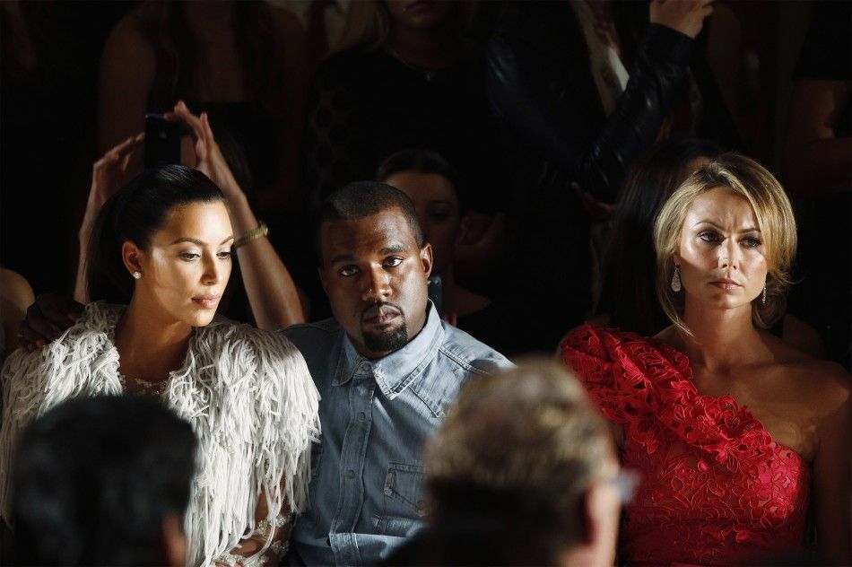Kanye West drapes his arm over the shoulder of Kim Kardashian L as they watch a showing of the Marchesa SpringSummer 2013 collection during New York Fashion Week, September 12, 2012.