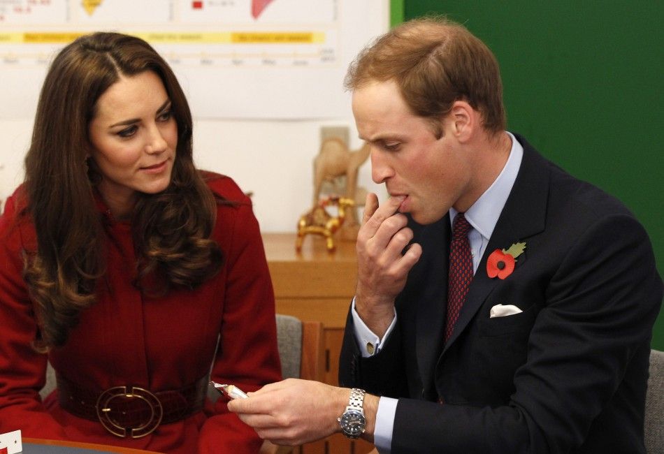 Britains Prince William watched by his wife Catherine, Duchess of Cambridge, tastes a high energy paste during a visit to the UNICEF emergency supply centre in Copenhagen, Denmark