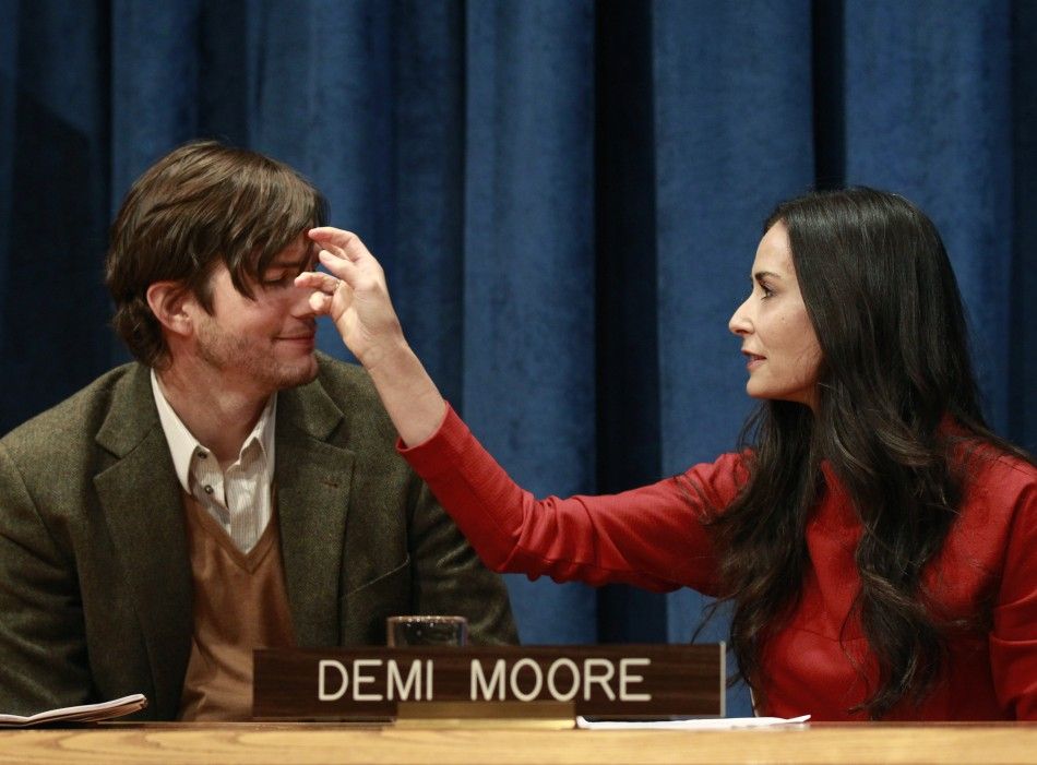 Actress Demi Moore brushes her husband, Ashton Kutchers hair, prior to a news conference at the United Nations Headquarters in New York