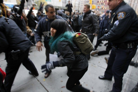 An Occupy Wall Street demonstrator is pushed out of the way by police officers as they make an arrest in New York