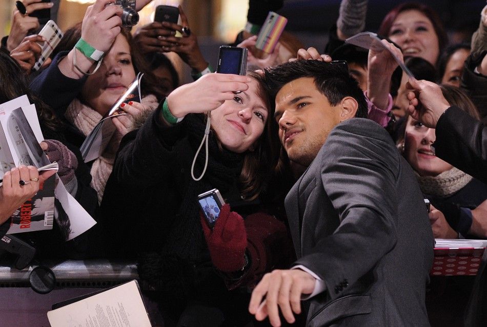Lautner poses with a fan at the premiere of quotThe Twilight Saga Breaking Dawn - Part 1quot in Los Angeles