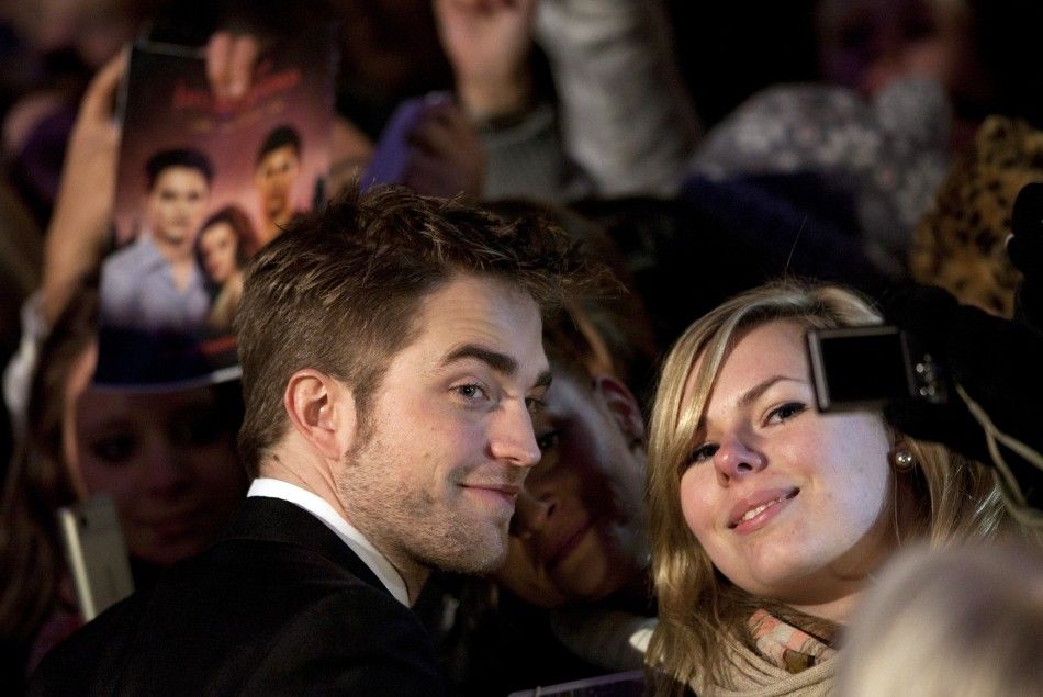 Cast member Robert Pattinson poses with a fan before the German premiere of the movie quotTwilight Saga Breaking Dawnquot in Berlin