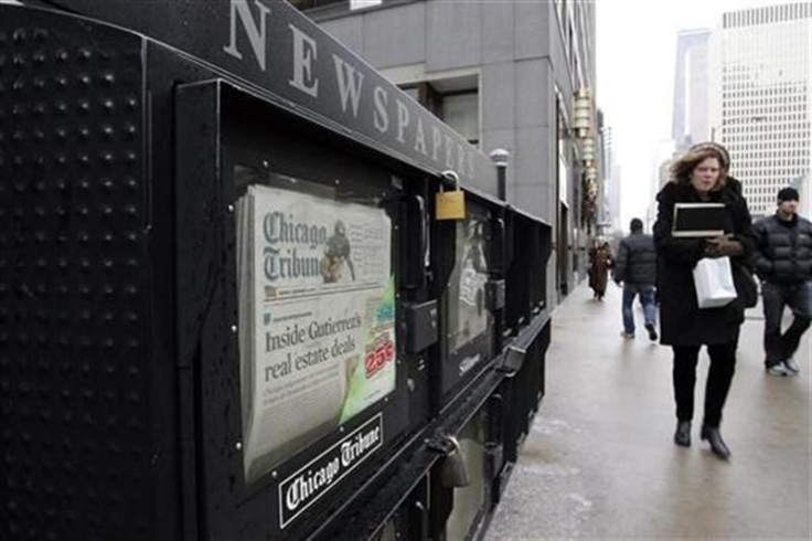People walk past a newspaper box across from the Chicago Tribune tower in Chicago, Illinois December 8, 2008.