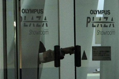 Man closes door of Olympus Corp&#039;s showroom in Tokyo