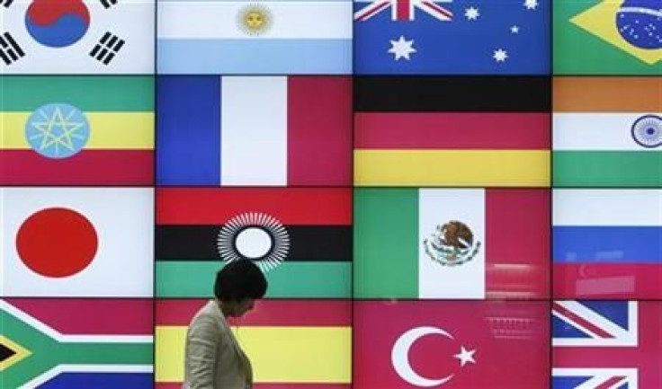 A woman walks by a signboard showing flags of the participating countries for the upcoming G20 Seoul Summit at venue of the summit in Seoul